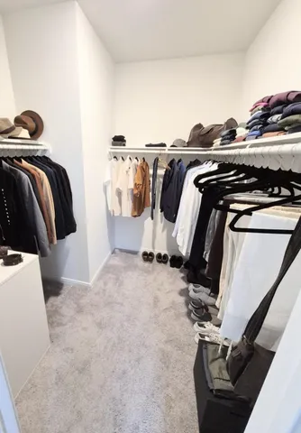 a view of walk in closet with clothes and shoes