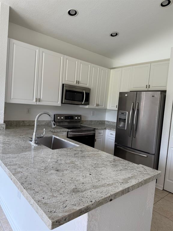1720 Northwest 78th Way, Unit 1720 Pembroke Pines, FL 33024 - Photo 4 of 9 a kitchen with granite countertop a refrigerator and a sink