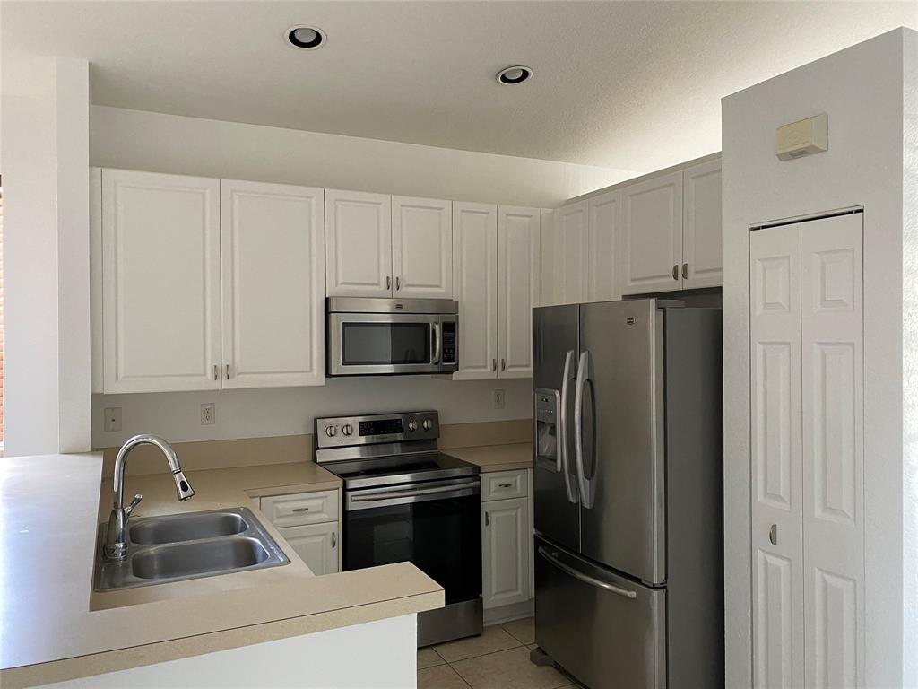 1720 Northwest 78th Way, Unit 1720 Pembroke Pines, FL 33024 - Photo 5 of 9 a kitchen with stainless steel appliances a refrigerator a sink a stove a microwave and cabinets