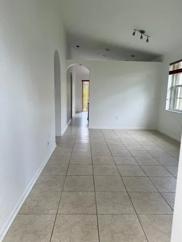 a view of a livingroom with an empty space and a window