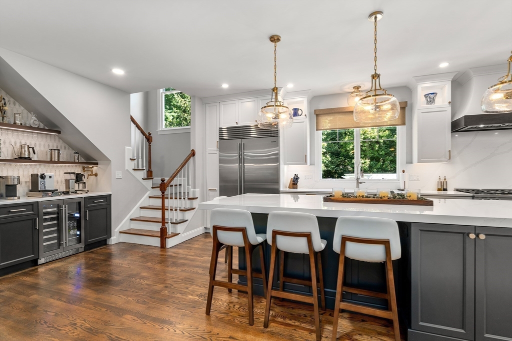 9 MacIntyre Drive North Reading, MA 01864 - Photo 9 of 41 a kitchen with kitchen island granite countertop a stove a sink a center island and chairs