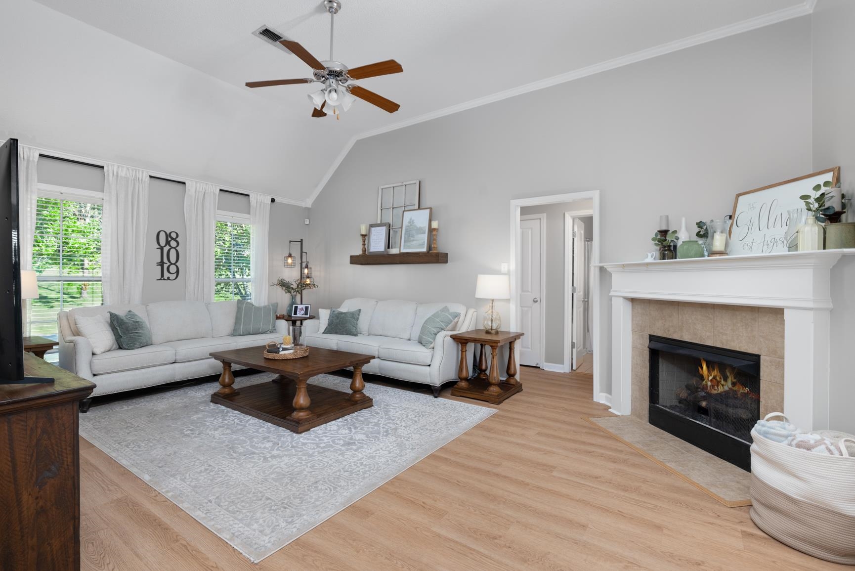 505 Terry Road Oakland, TN 38060 - Photo 10 of 40 Living room featuring ornamental molding, a tiled fireplace, light wood-style floors, ceiling fan, and high vaulted ceiling