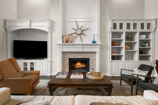 a living room with furniture fireplace and a large window