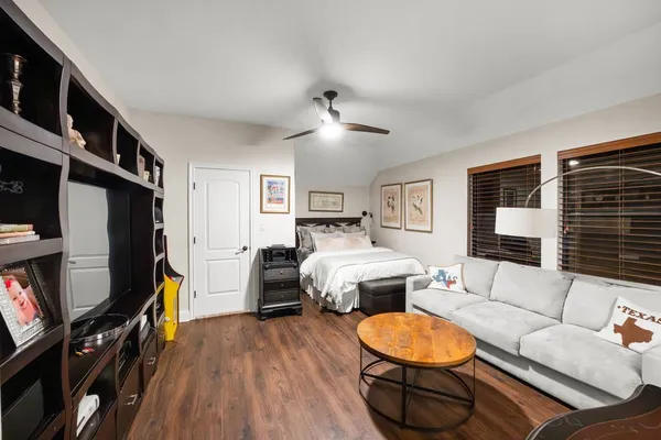 a living room with furniture a flat screen tv and a bookshelf