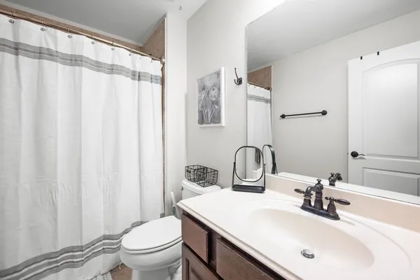 a bathroom with a sink a toilet and a mirror