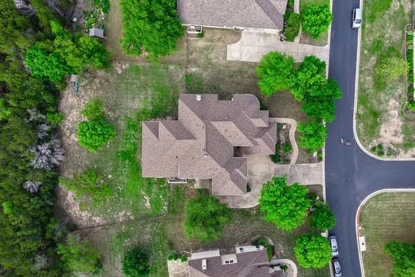 an aerial view of a house with garden space and a street view