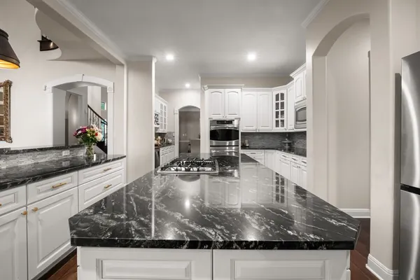 a view of a kitchen with kitchen island a sink appliances and a counter top space