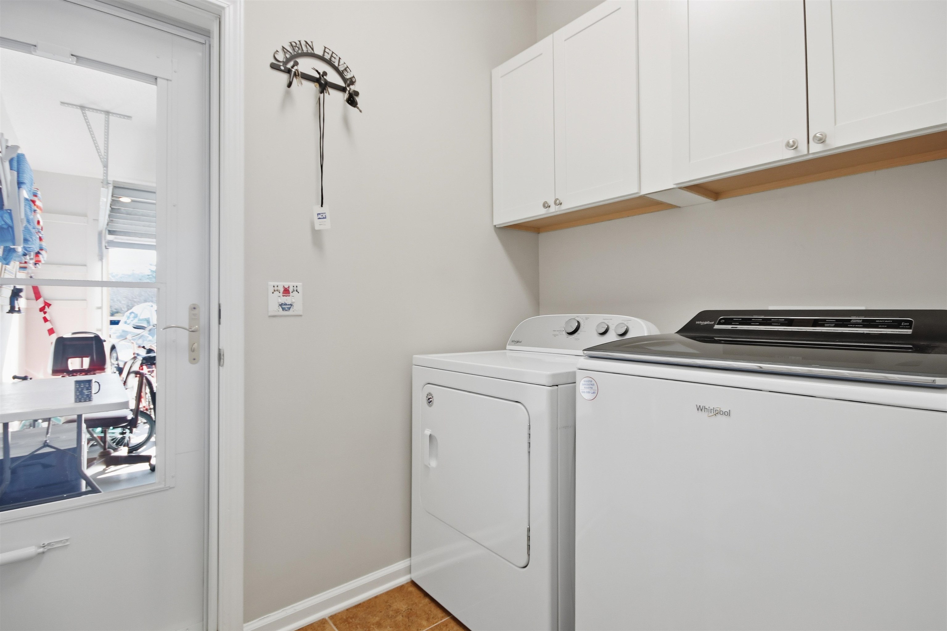 4 Guillemont Court Murrells Inlet, SC 29576 - Photo 16 of 40 Laundry area with cabinet space, washer and dryer, and light tile patterned flooring