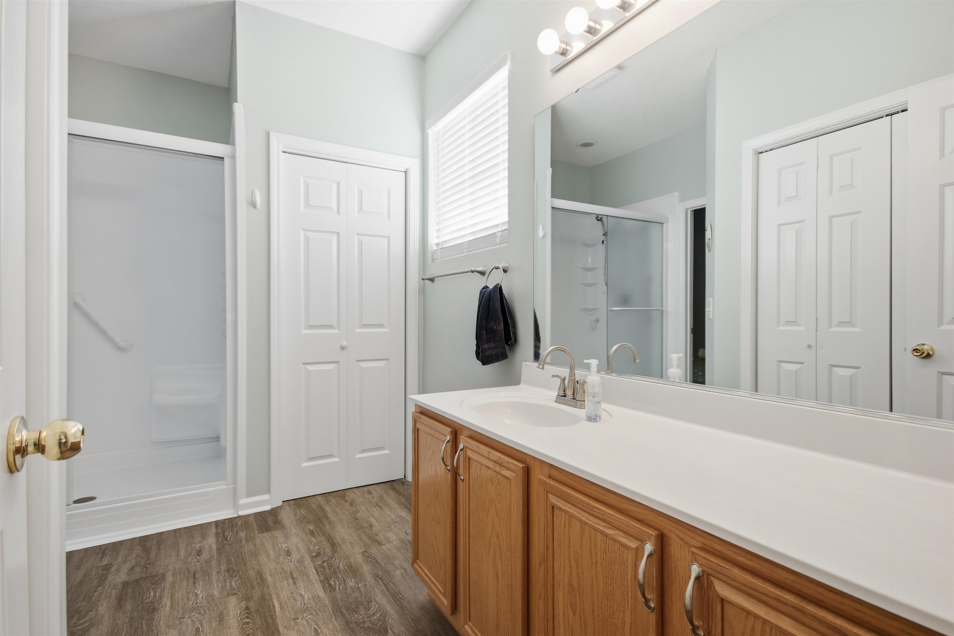 4 Guillemont Court Murrells Inlet, SC 29576 - Photo 26 of 40 Bathroom featuring a closet, a shower stall, vanity, and dark wood-type flooring