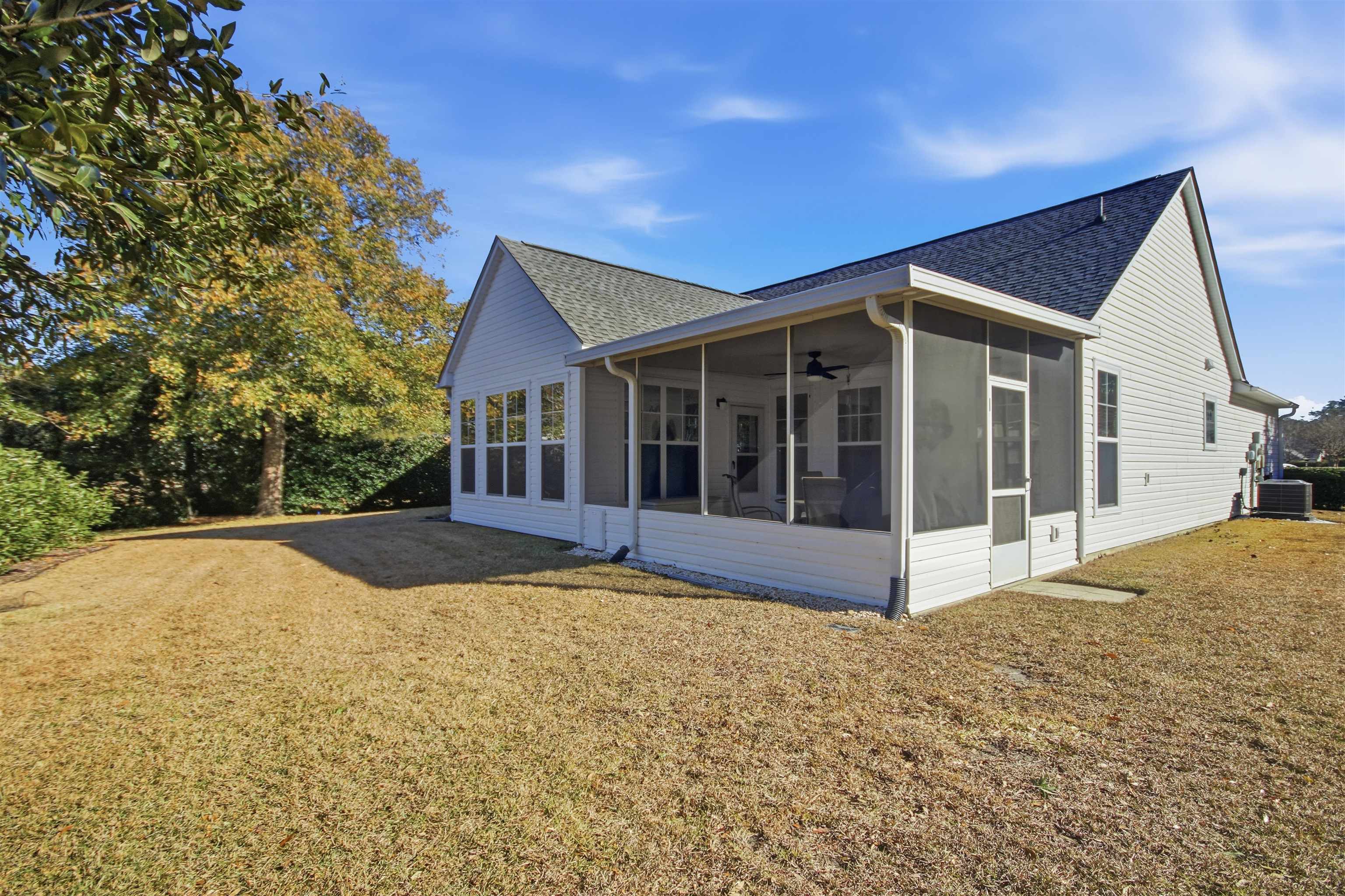 4 Guillemont Court Murrells Inlet, SC 29576 - Photo 30 of 40 View of side of home with a sunroom, a shingled roof, and a lawn