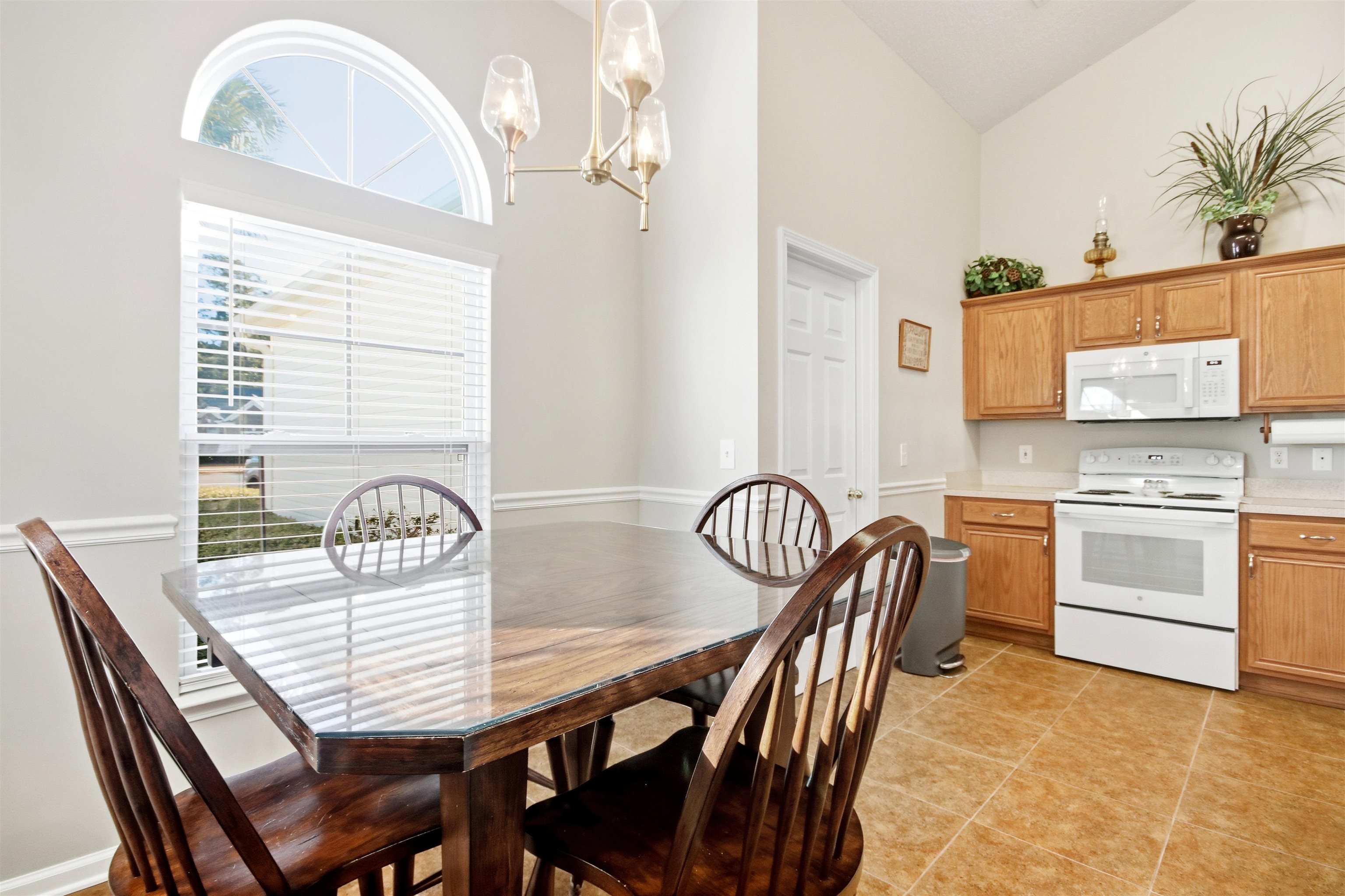 4 Guillemont Court Murrells Inlet, SC 29576 - Photo 7 of 40 Dining room featuring high vaulted ceiling, a chandelier, and light tile patterned floors