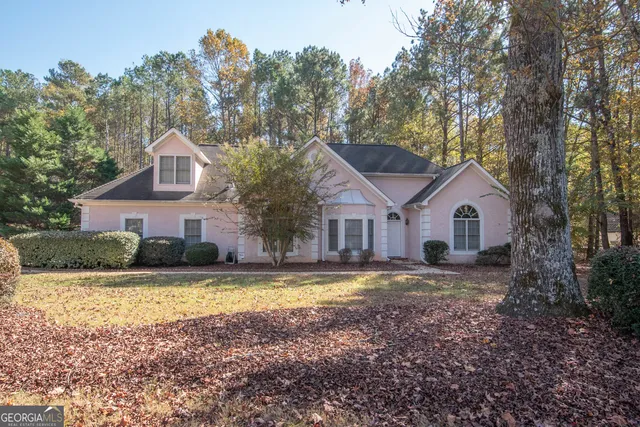 a front view of a house with a yard covered with trees