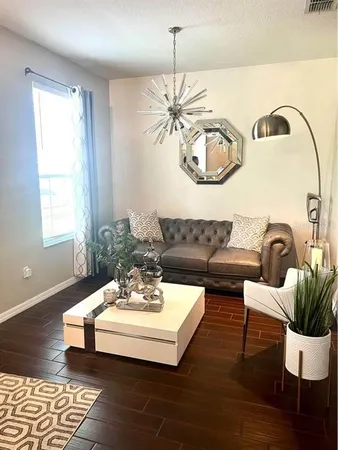 a living room with furniture and a chandelier