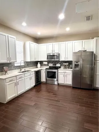 a kitchen with white cabinets and white appliances