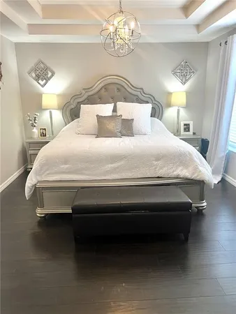 a spacious bedroom with a bed and a chandelier