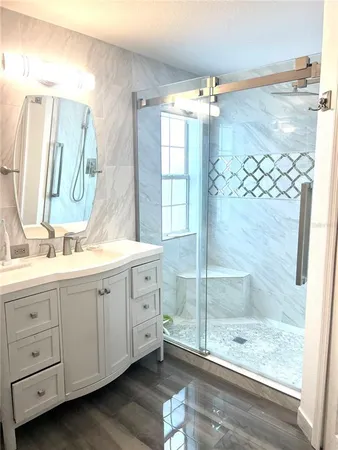 a bathroom with a double vanity sink mirror and shower