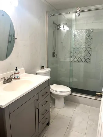 a bathroom with a sink a toilet and shower
