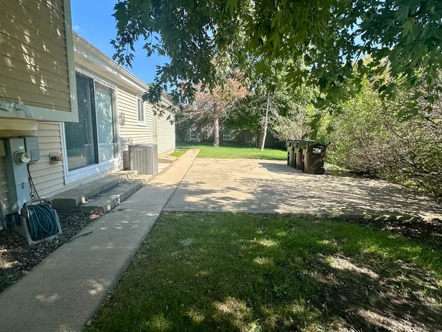 a view of a house with a yard and a large tree