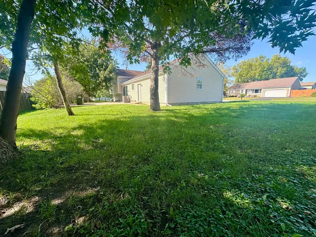 a view of building with a big yard and large trees