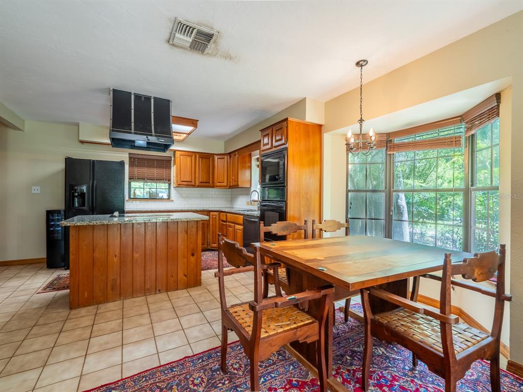 23610 Northeast 154th Place Road Fort McCoy, FL 32134 - Photo 14 of 44 a view of a dining room with furniture a chandelier and wooden floor