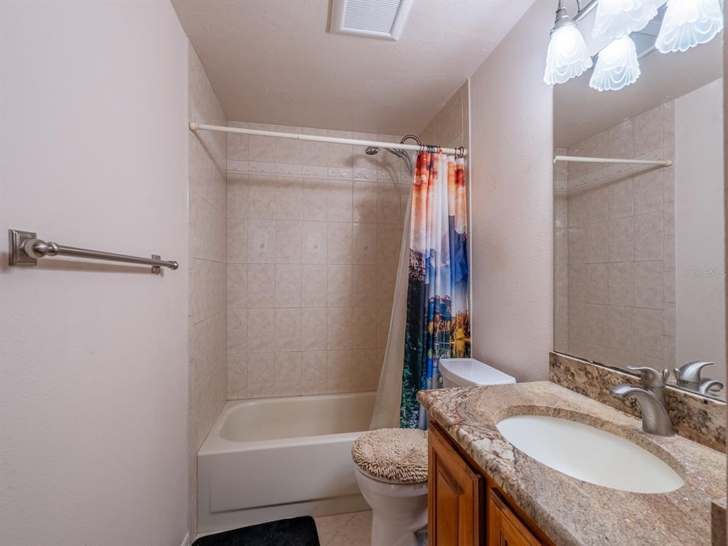 23610 Northeast 154th Place Road Fort McCoy, FL 32134 - Photo 28 of 44 a bathroom with a granite countertop sink toilet and shower