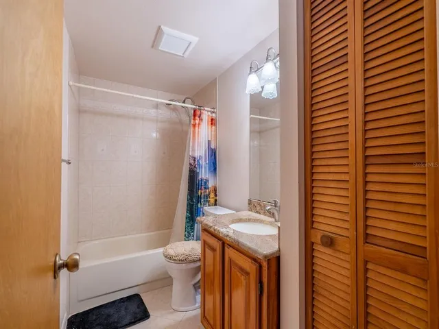 a view of swimming pool with lawn chairs and plants