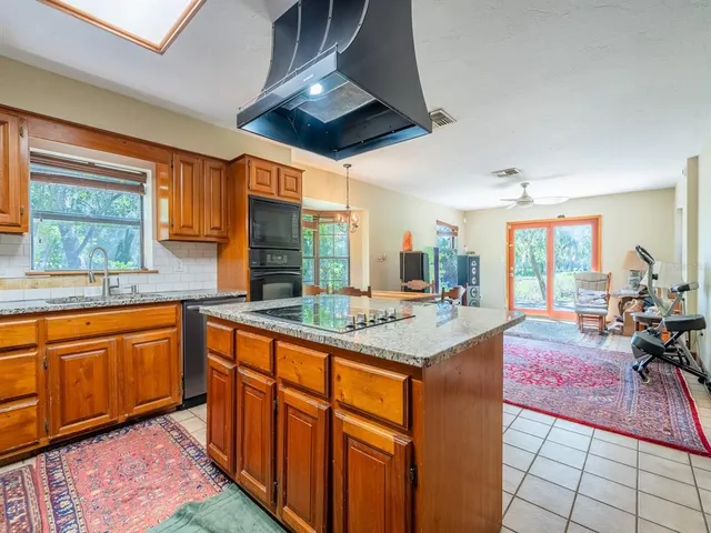 a kitchen with stainless steel appliances granite countertop a sink and a refrigerator