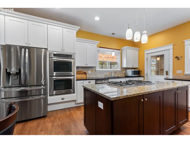 a kitchen with stainless steel appliances a stove a refrigerator and a sink