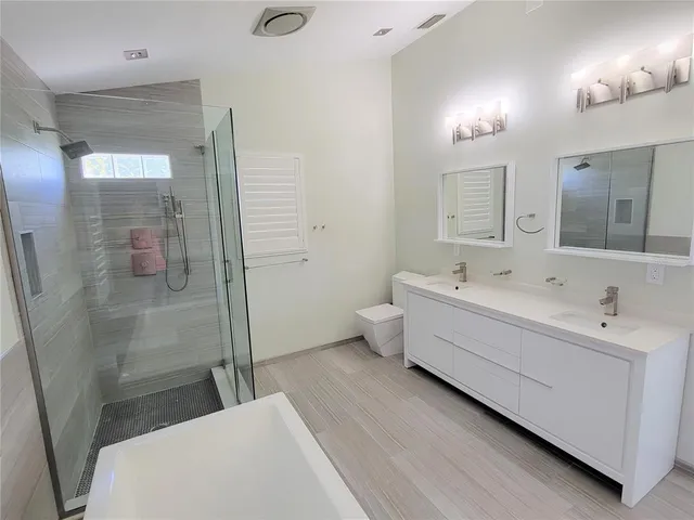 a bathroom with a bathtub a sink and mirror