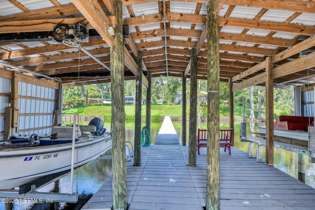 a view of a dining room with furniture a chandelier and wooden floor