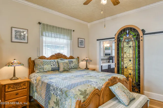 a bedroom with a bed and a mirror on the dresser