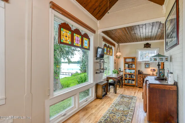 a view of white house with a yard and large tree