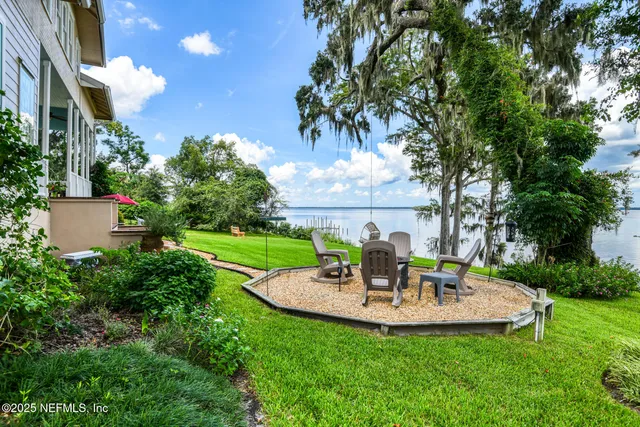 a living room with furniture a fireplace and a floor to ceiling window