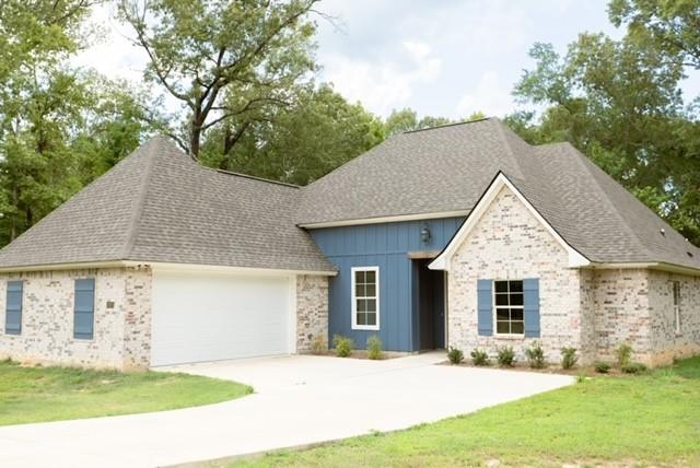 1025 VOSS Road Stonewall, LA 71078 - Photo 2 of 13 a front view of a house with a yard and garage