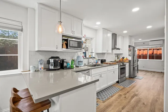 a kitchen with kitchen island granite countertop a sink cabinets and window