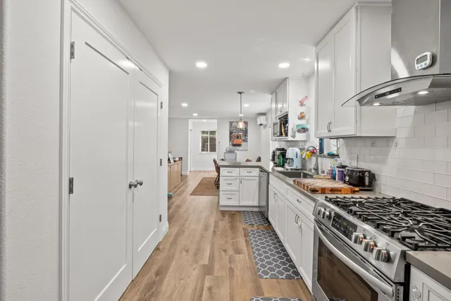 a large kitchen with stainless steel appliances granite countertop a lot of counter space and a sink