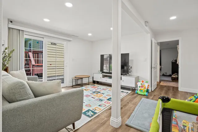 a living room with furniture and wooden floor