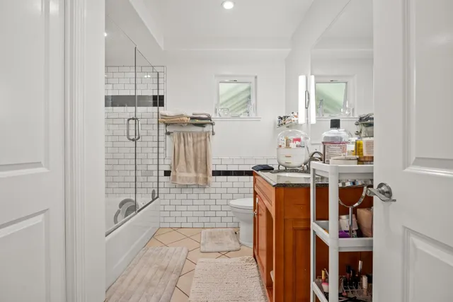 a living room with stainless steel appliances furniture a rug and a view of kitchen