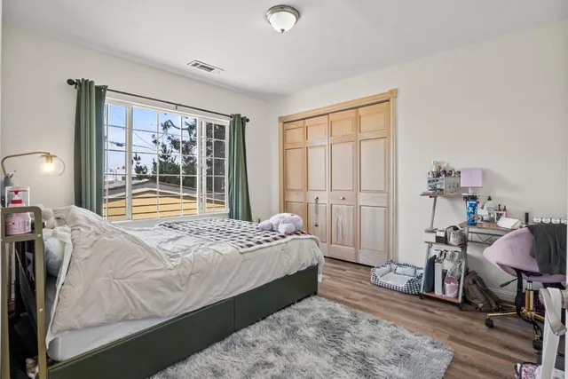 a bedroom with a bed and wooden floor