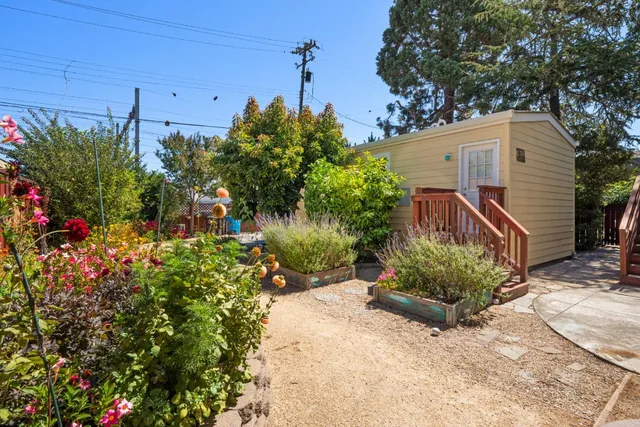 a front view of a house with a yard and potted plants