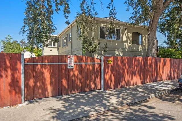 a view of a house with a wooden fence