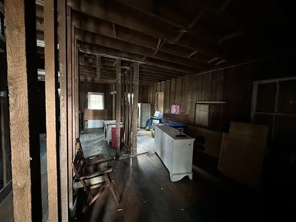 a view of a hallway with wooden floor and furniture