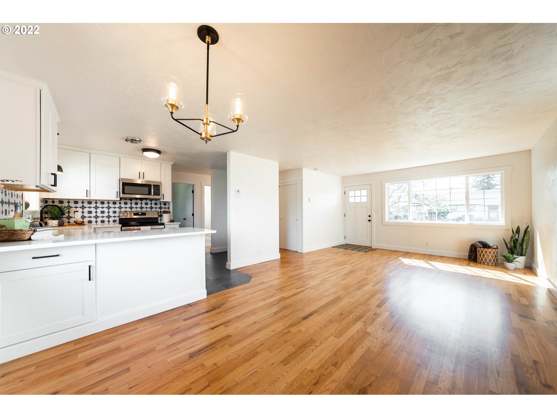1218 N Street Springfield, OR 97477 - Photo 5 of 27 a view of an empty room with wooden floor and kitchen view