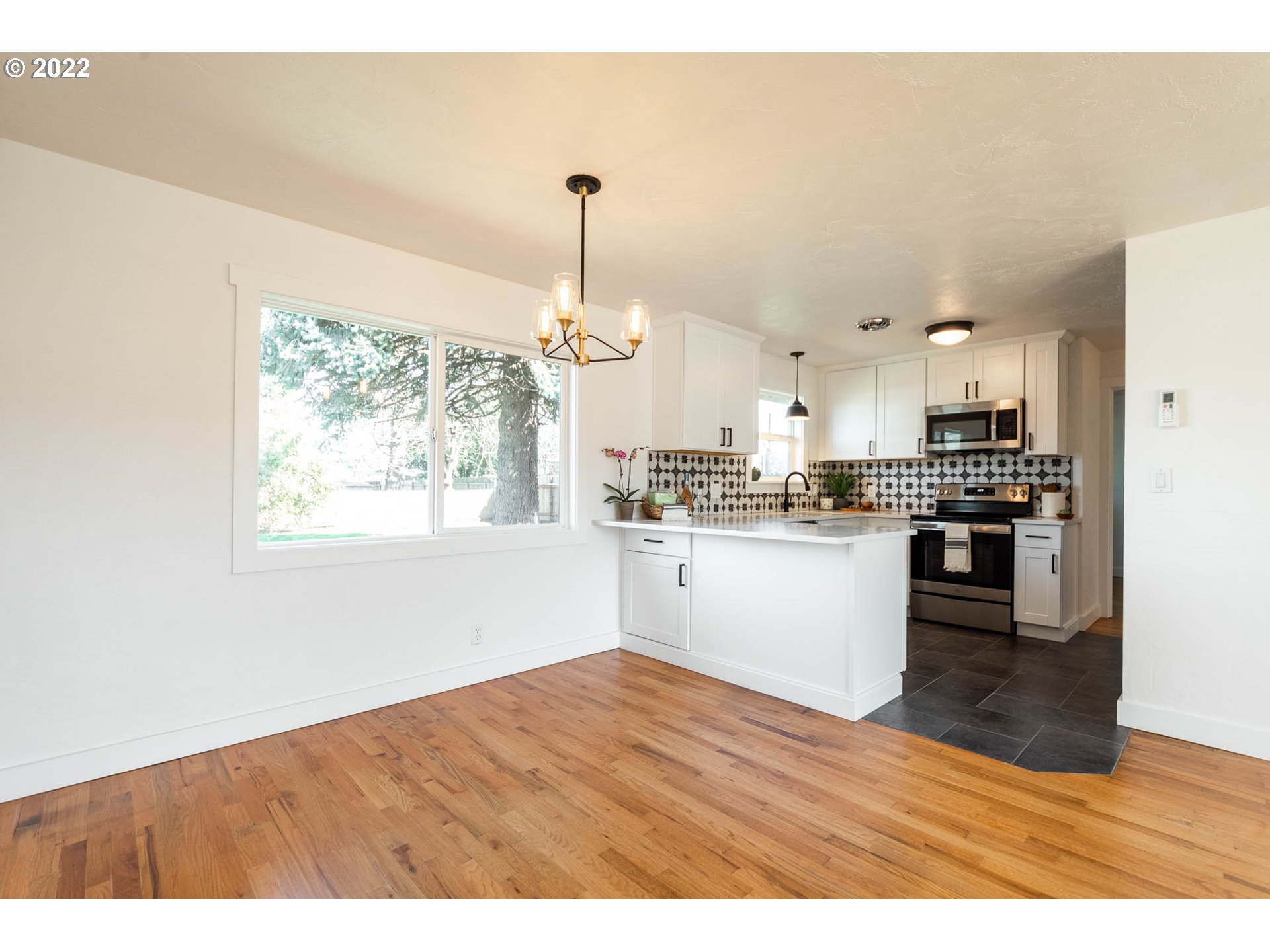 1218 N Street Springfield, OR 97477 - Photo 6 of 27 a kitchen with stainless steel appliances granite countertop a refrigerator a sink dishwasher a stove and white countertops with wooden floor