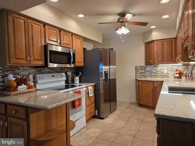 a kitchen that has a lot of cabinets in it and stainless steel appliances