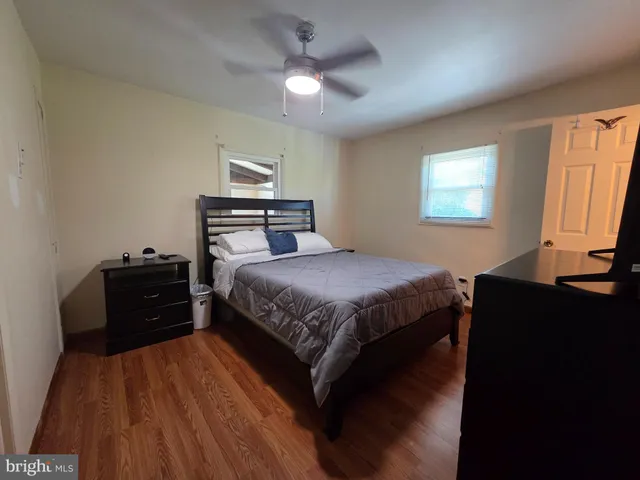 a bedroom with a bed and a flat tv screen on dresser