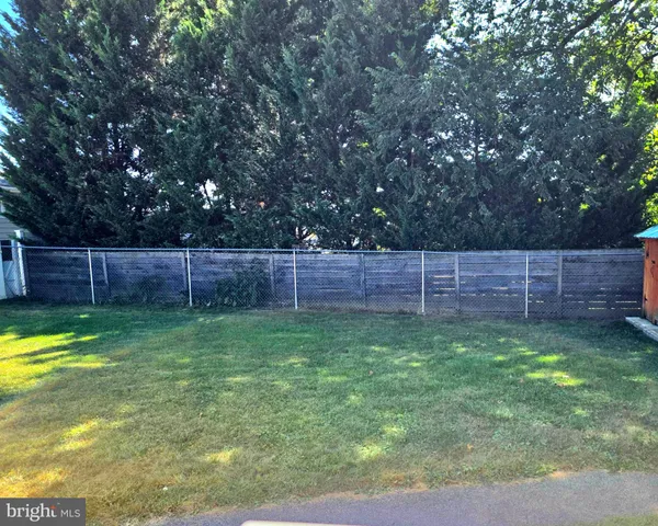 a view of a backyard with wooden fence
