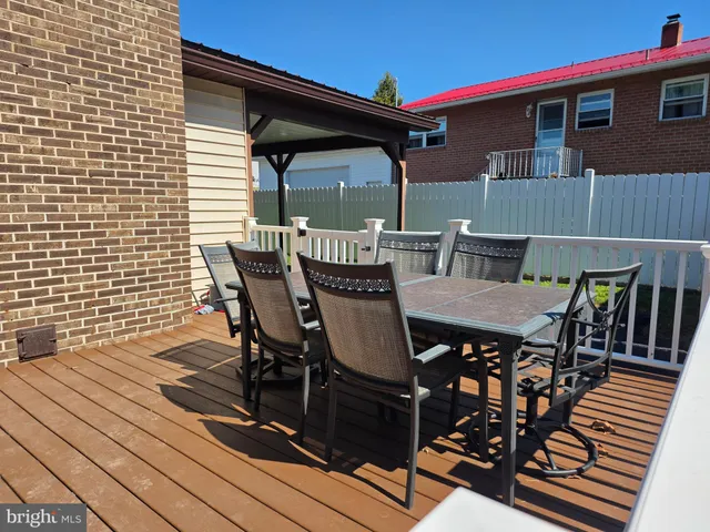 a view of a patio with table and chairs with wooden floor and fence