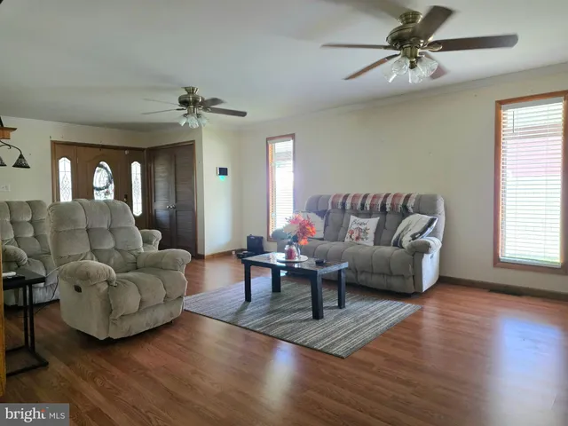 a living room with furniture and a wooden floor