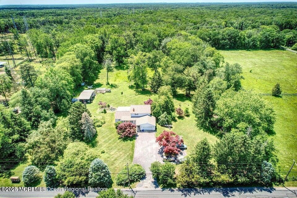 an aerial view of residential house with outdoor space and trees all around